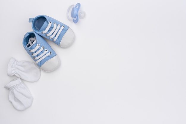 two baby shoes and pacifier on a white background with copy space for the text