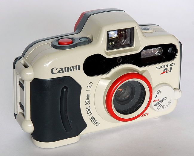 a white and black camera with red accents