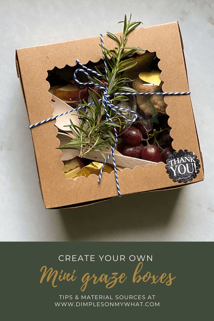 an open box filled with fruit on top of a white counter next to a sign that says create your own mini graze boxes