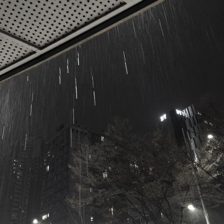 the rain is falling down in the city at night, and it's raining