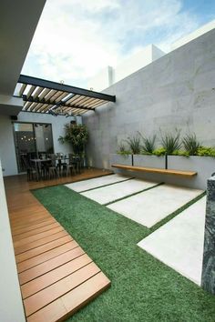 an outdoor patio with grass and wooden benches