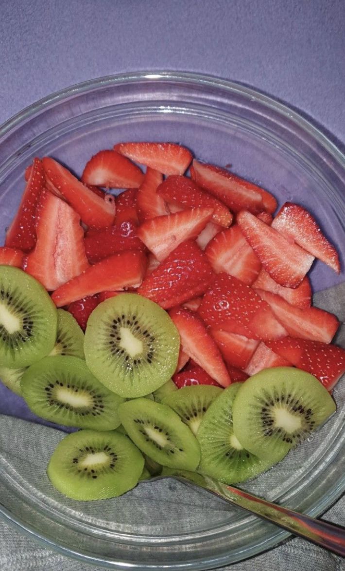 sliced kiwis and strawberries in a glass bowl