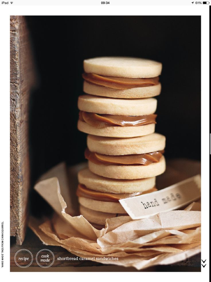 a stack of cookies sitting next to each other on top of a wooden table covered in wax paper