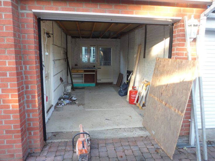 an open garage door with various items in the doorway and on the ground next to it