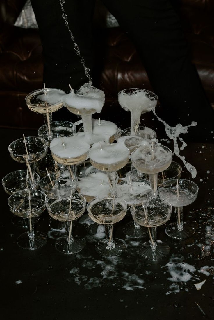 champagne being poured into wine glasses on a table