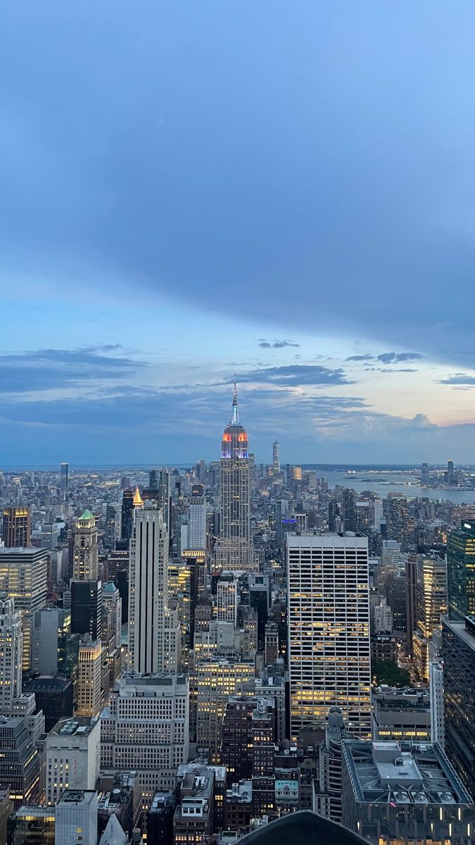 the city skyline is lit up at night with skyscrapers and other tall buildings in the foreground