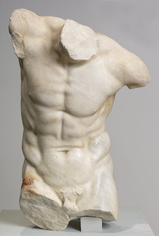 a white marble sculpture of a man with his back turned to the side and muscles exposed