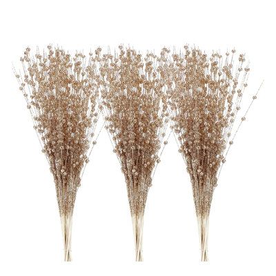 three tall vases filled with dried flowers on top of each other in front of a white background