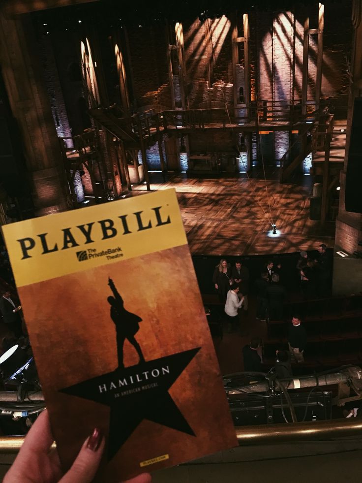 a person holding up a book in front of a stage