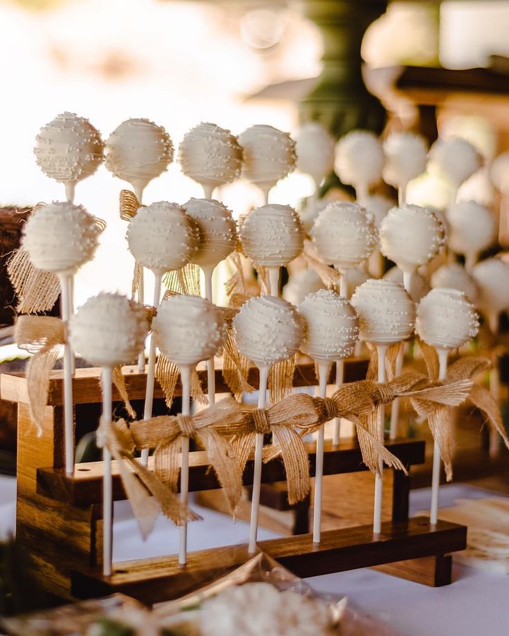 there are many lollipops that are on the wooden stand and tied with burlap