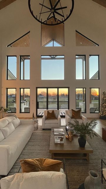 a large living room with high ceilings and lots of windows