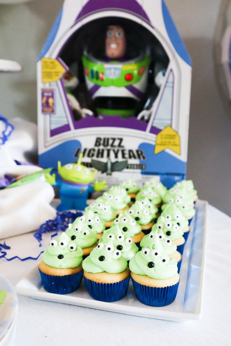 the toy story buzz lightyear cupcakes are displayed on a plate with green frosting