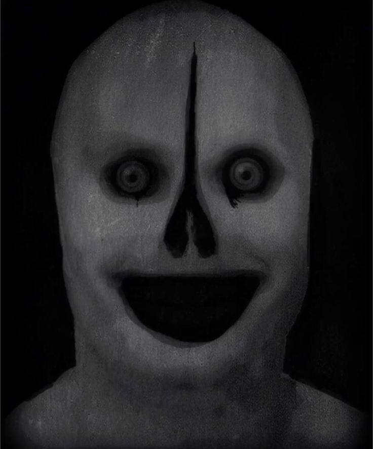 a creepy mask with big eyes and a smile on it's face is shown in black and white