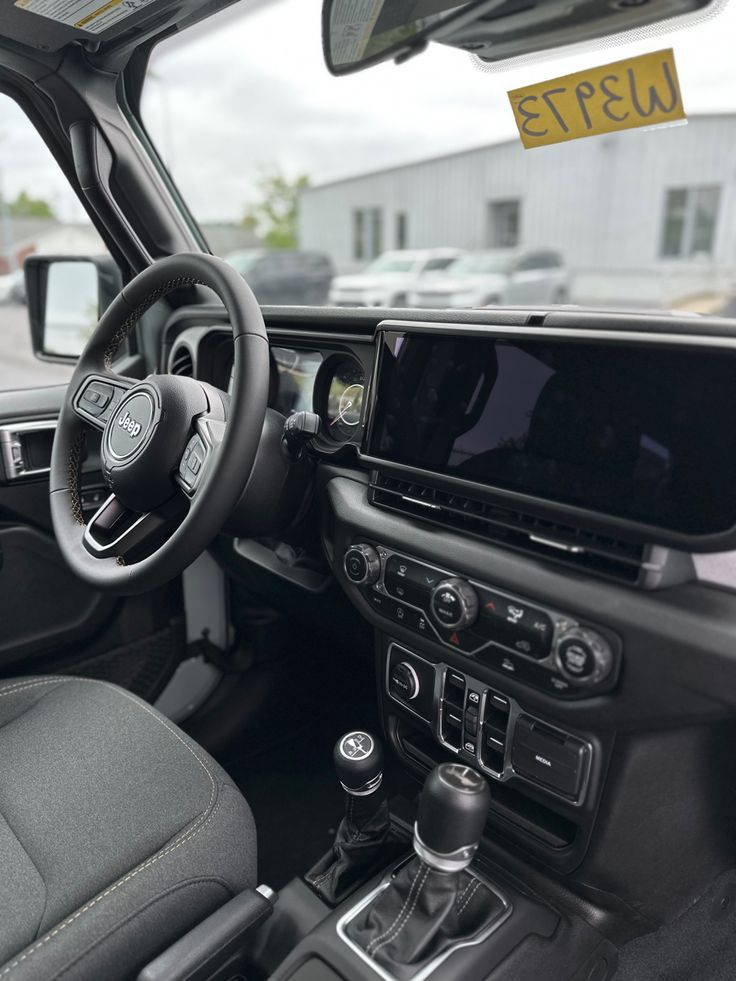 the interior of a vehicle with dashboard, steering wheel and display screen on it's left side