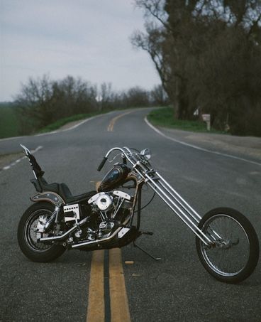 the motorcycle is parked on the side of the road in the middle of the street