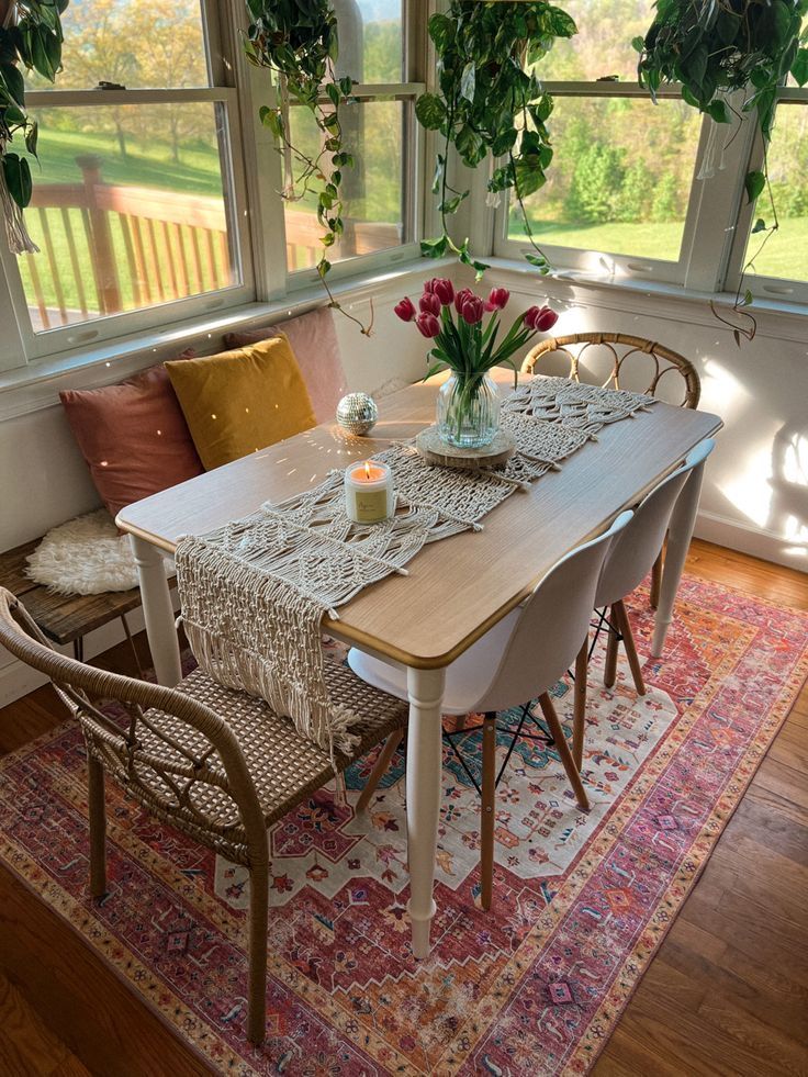 a dining room table and chairs with flowers in vases on top of the table