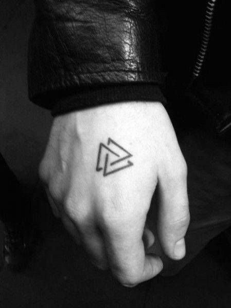 a hand with a small triangle tattoo on it