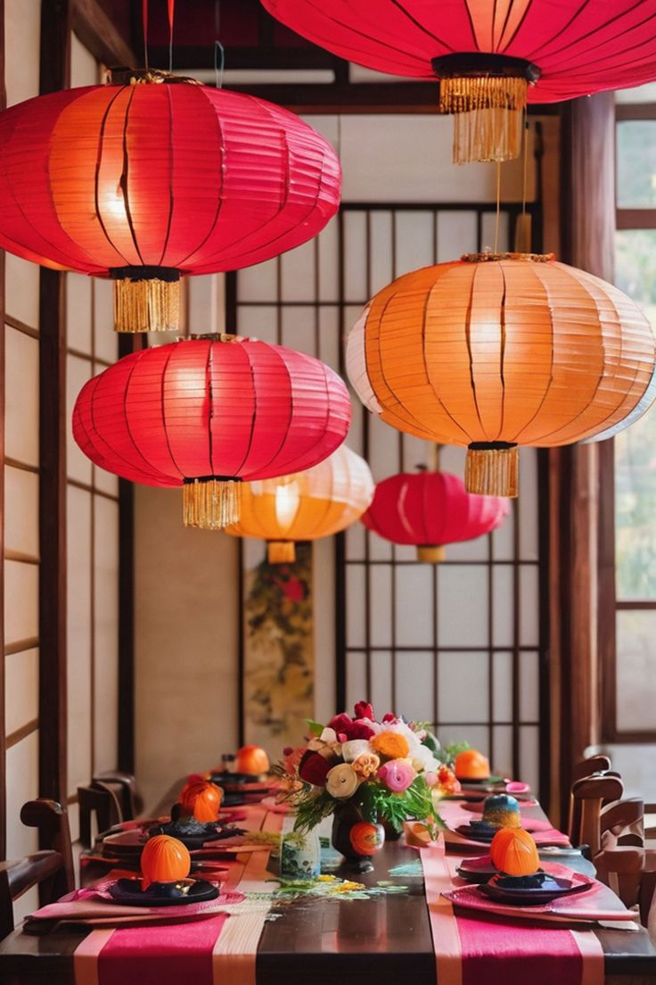 a long table with red and orange lanterns hanging from it's ceiling over it