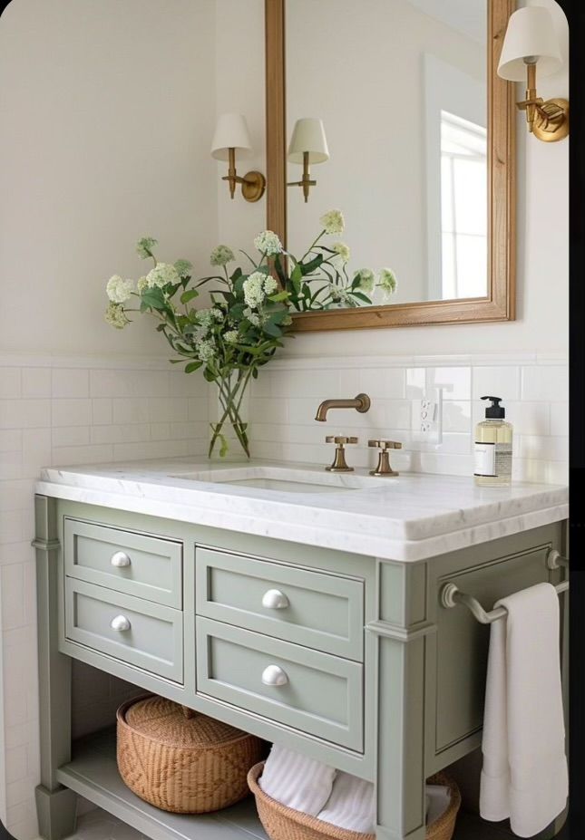 a bathroom with a sink, mirror and flowers in the vase on the counter top