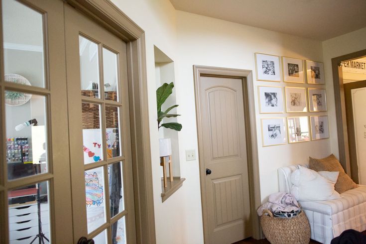 a living room filled with furniture and pictures on the wall next to an open door