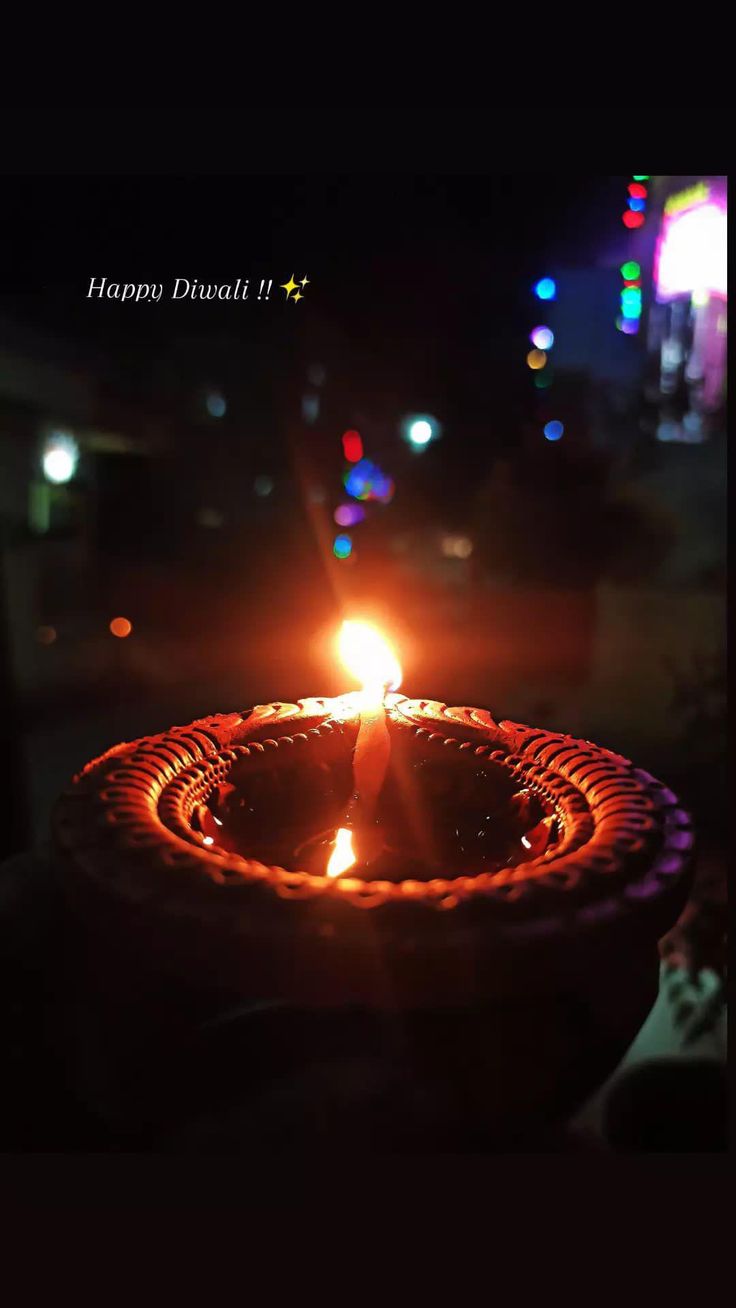 a lit candle in the middle of a dark room