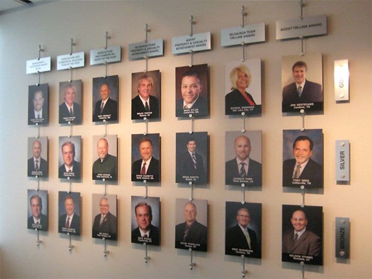 a group of men's heads hanging on a wall with signs attached to them