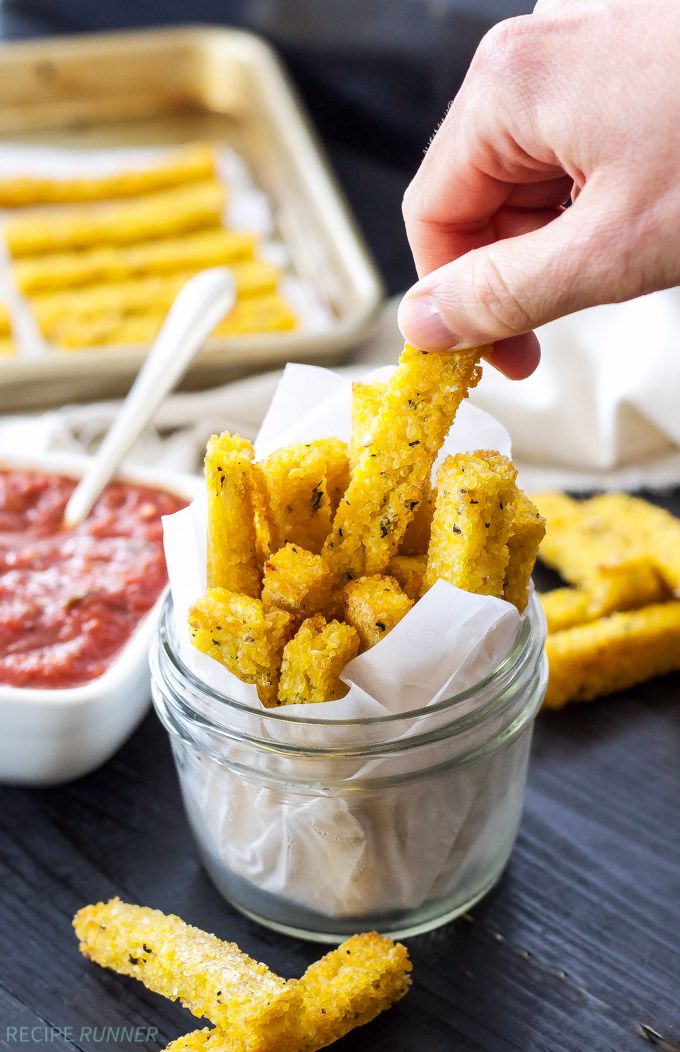 a person dipping some kind of food into a small glass jar with sauce on the side