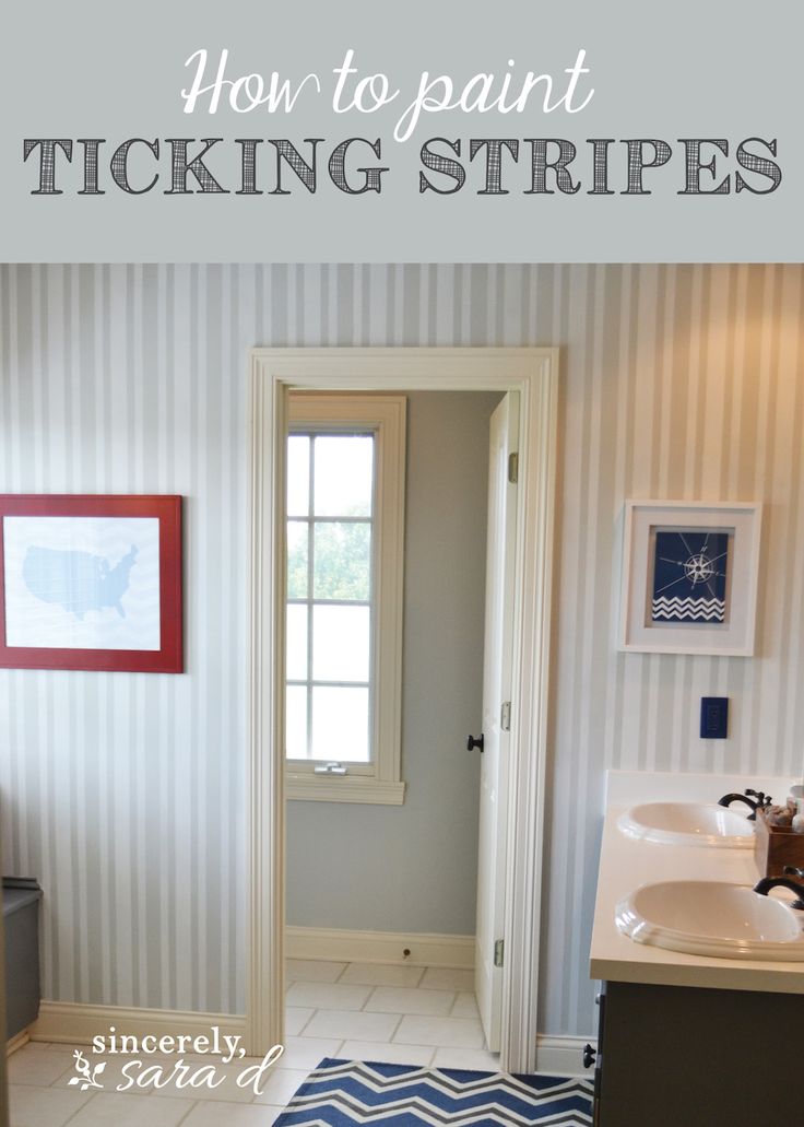 a bathroom with blue and white striped wallpaper next to a doorway that leads to a sink