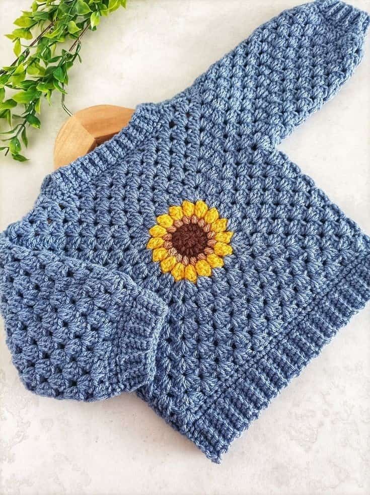 a crocheted blue scarf with a yellow flower on the front and back side