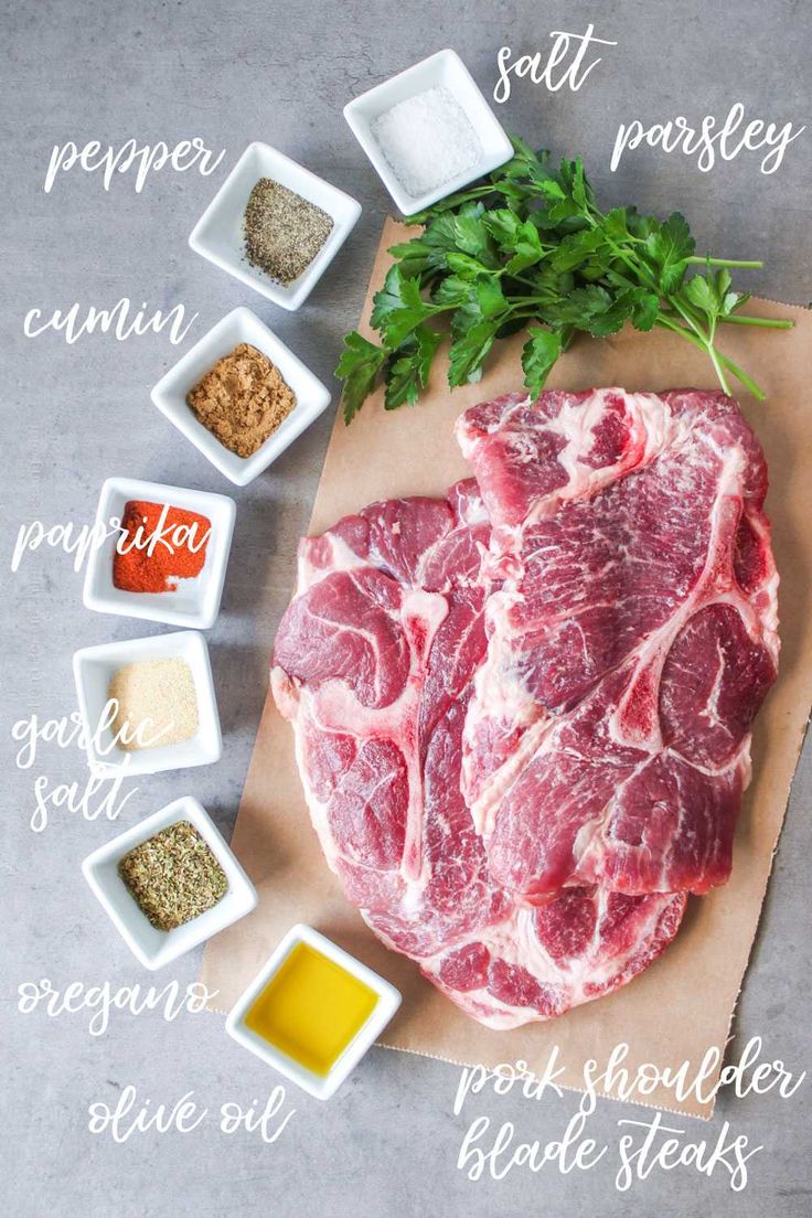 raw meat on a cutting board with spices and seasonings around it, including parsley