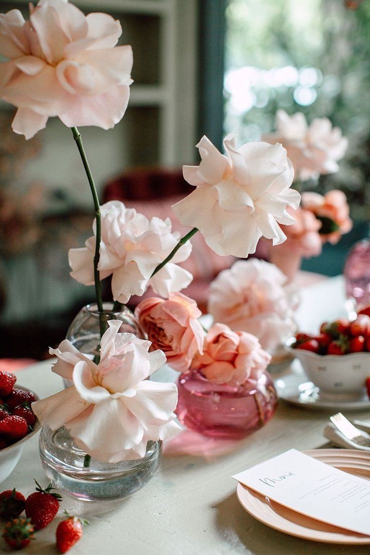 pink flowers and strawberries are on the table