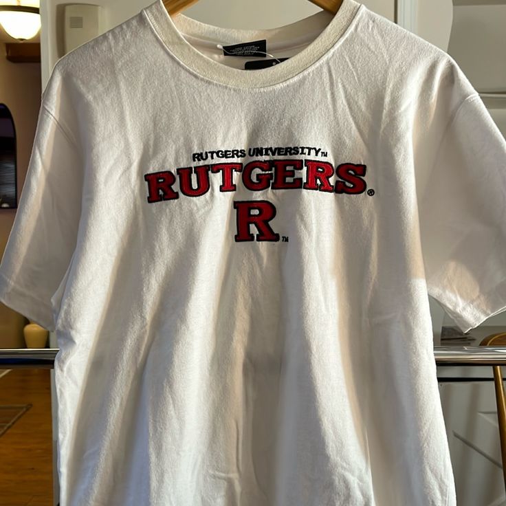 Xl Youth Size (20) Embroidered Rutgers White Short Sleeve Top With University Logo, White Tops With University Logo For Sports Season, White Tops With University Logo For Game Day, Collegiate White T-shirt With University Logo, White University Logo T-shirt For Game Day, White University Logo T-shirt With Crew Neck, White Crew Neck T-shirt With University Logo, University Logo Cotton Short Sleeve Top, White University Logo T-shirt For Fans