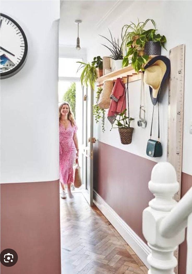 a woman in a pink dress is walking down the hallway