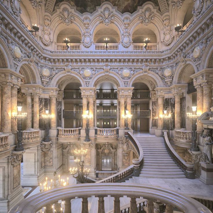 the inside of a building with many stairs and chandeliers on either side of it