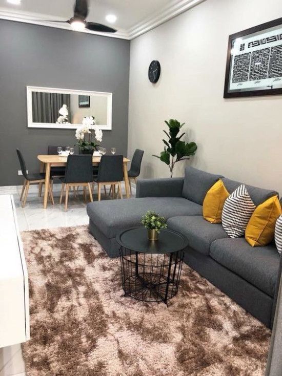 a living room filled with furniture and a rug on top of a carpeted floor