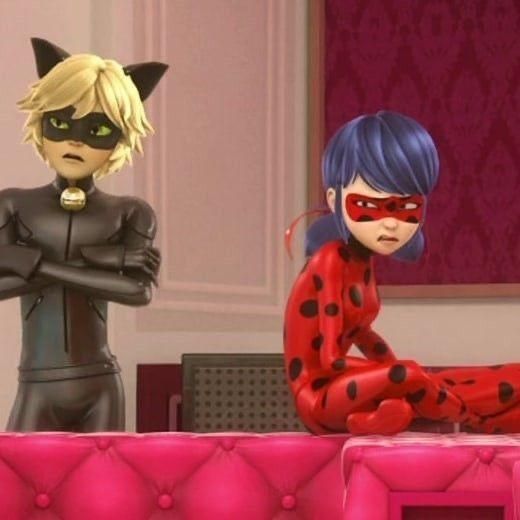 two cartoon characters dressed in black and red sitting next to each other on a pink couch