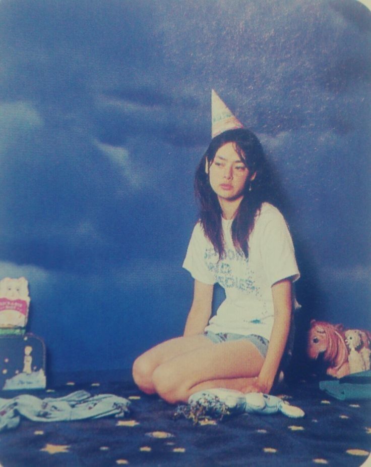 a woman sitting on the floor wearing a party hat