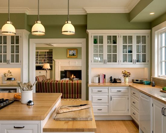 a kitchen with green walls and white cabinets