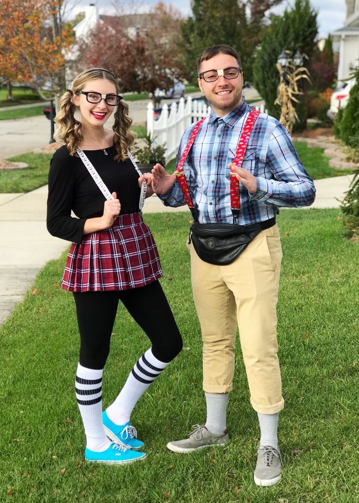 a man and woman dressed up in costume posing for a photo on the grass with their arms around each other