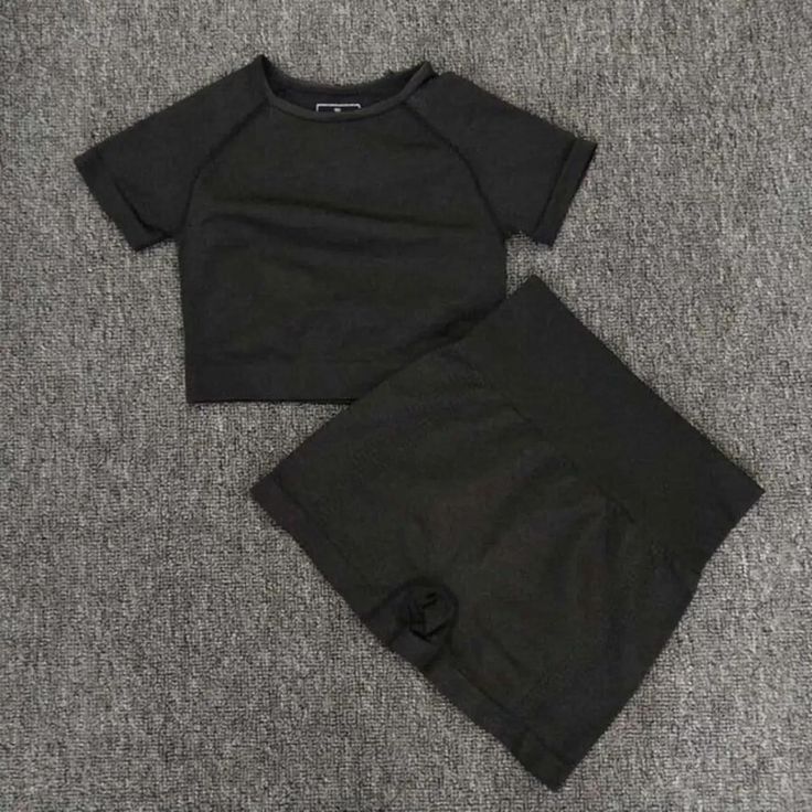 a black shirt and shorts are laying on the floor