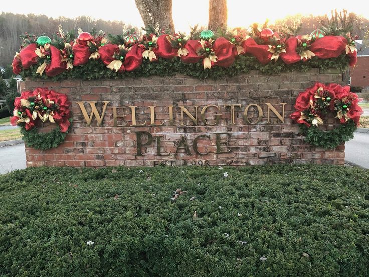 a brick sign that says wellington place with poinsettis on it