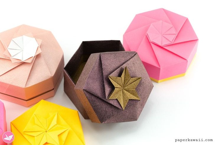 four origami boxes sitting next to each other on top of a white surface