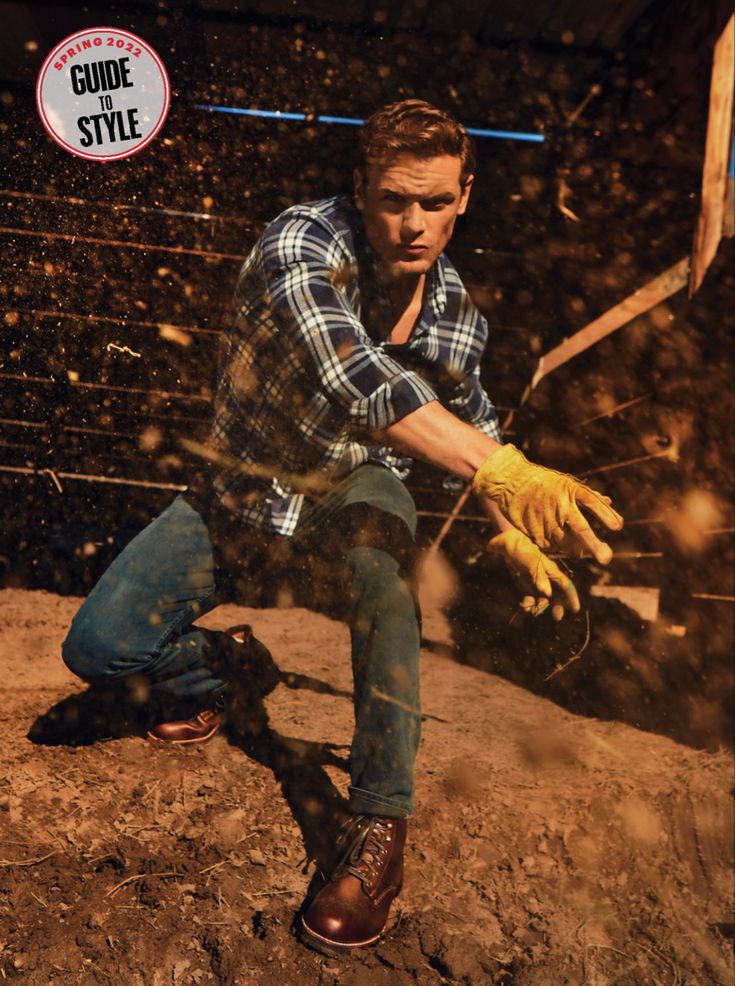 a man kneeling down in the dirt with his hand on a skateboard