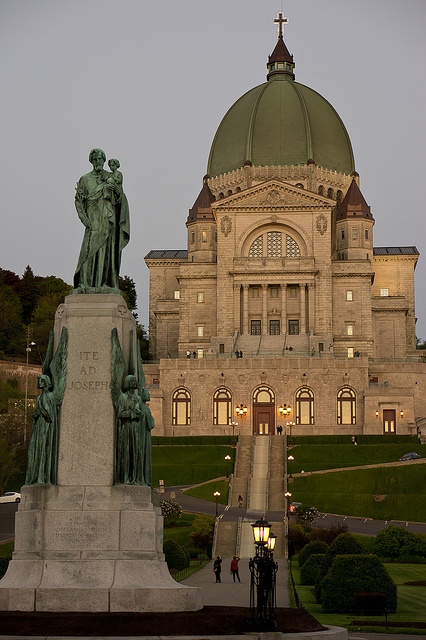 a statue in front of a large building with a dome