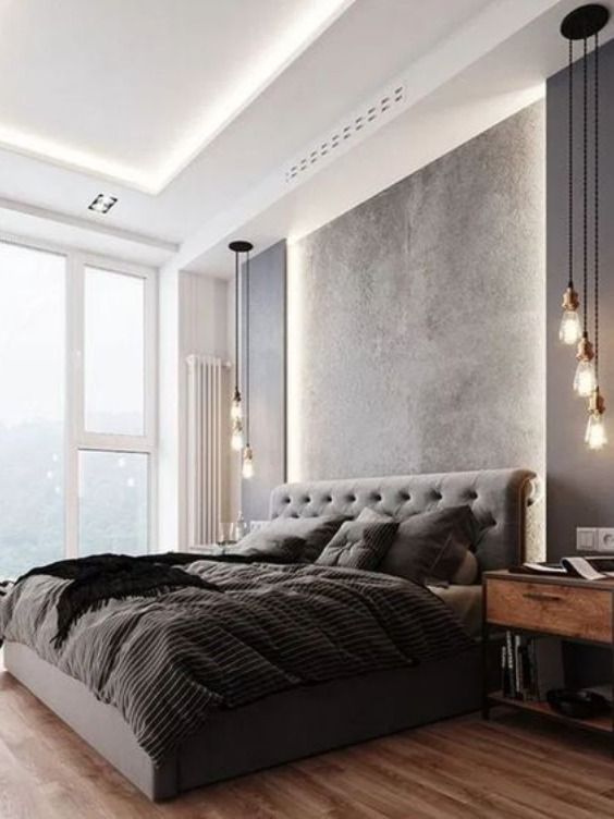 a large bed sitting in the middle of a bedroom next to a tall window with lights on it