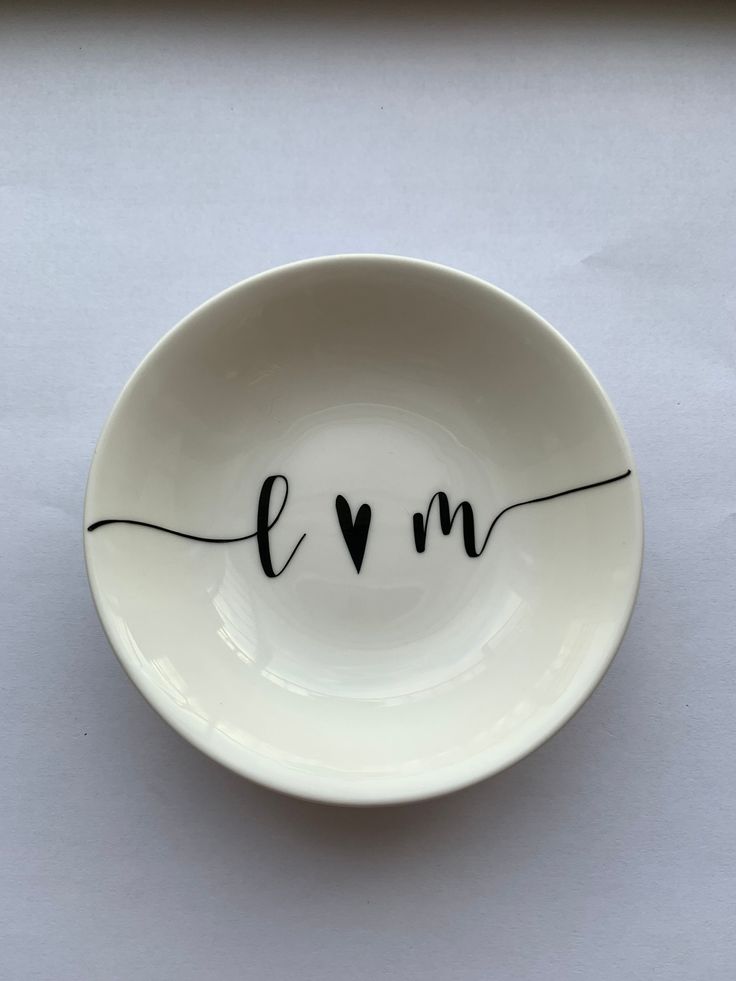 a white bowl with the word love written in black ink on it's side