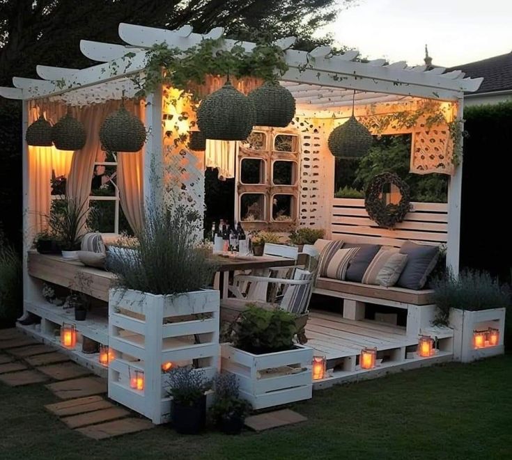 an outdoor seating area is lit up with candles