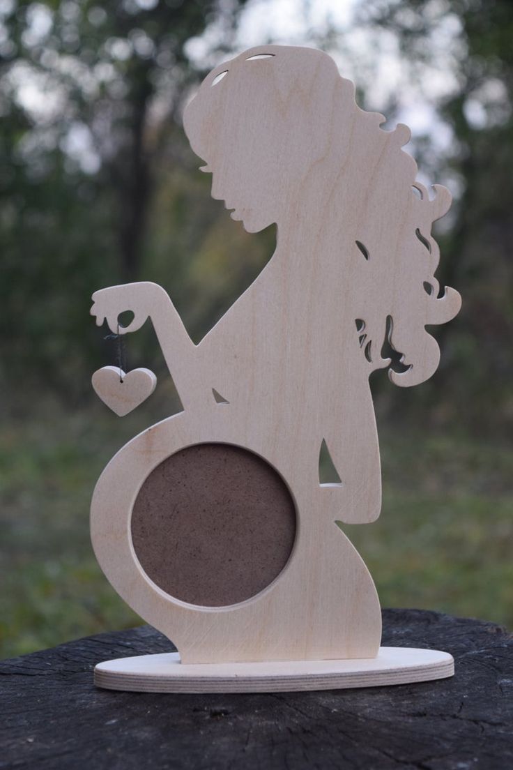 a wooden sculpture of a woman holding a heart