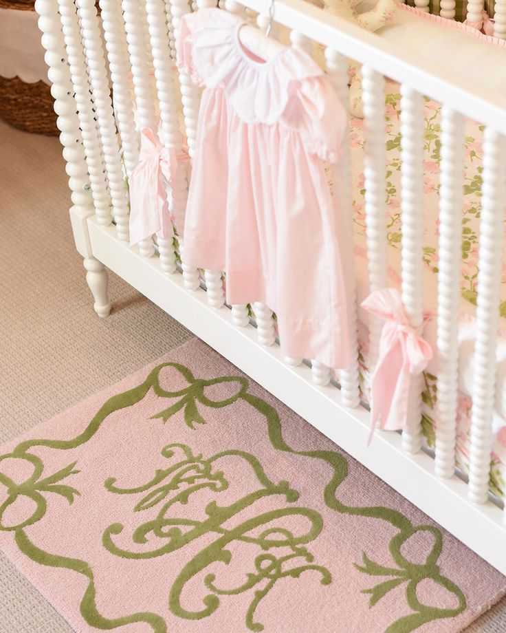 a baby crib with pink and green decor