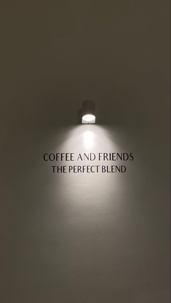 the words coffee and friends are lit up in front of a wall with a light on it